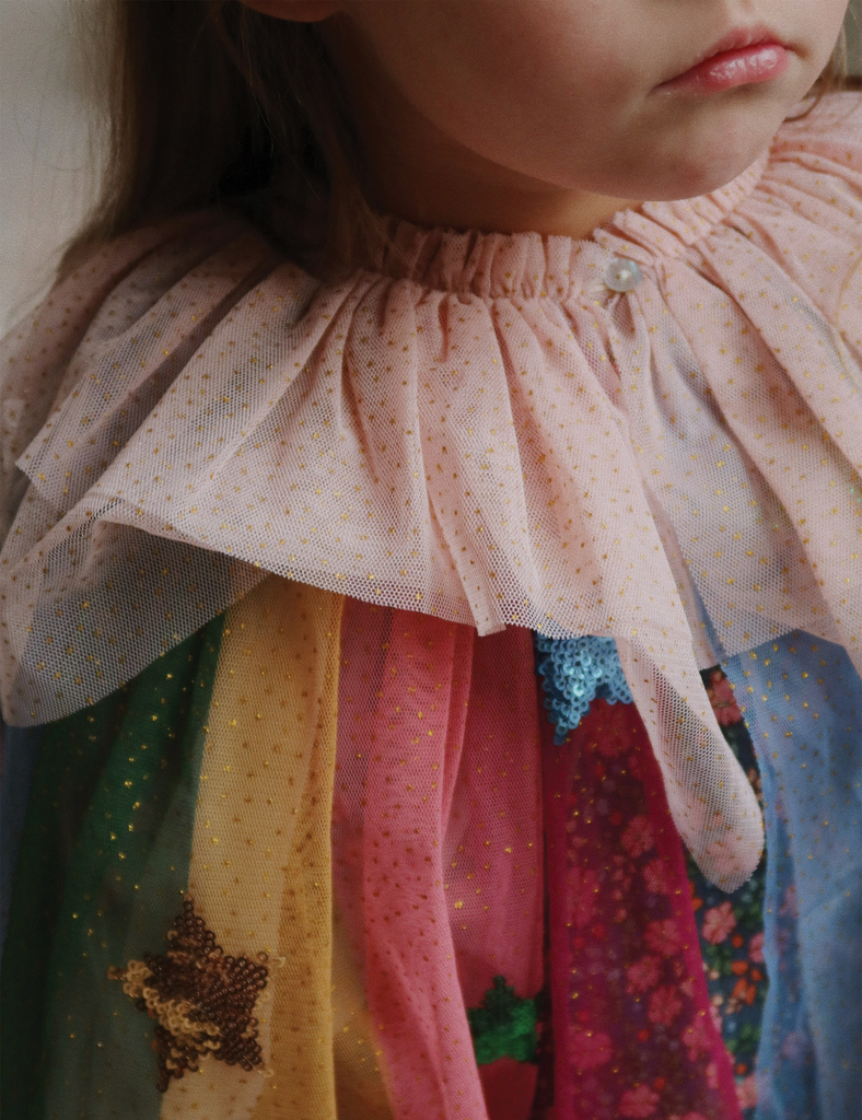 Close-up of a child's colorful dress with a ruffled collar.