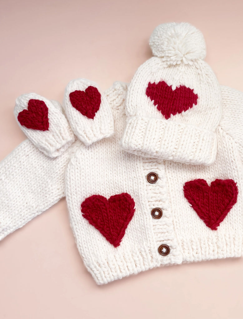 Red Heart Beanie in cream flat lay image.