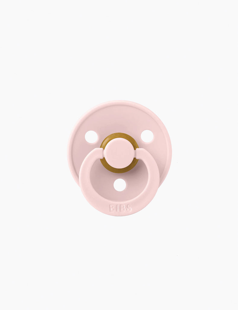 Pink pacifier on a white background
