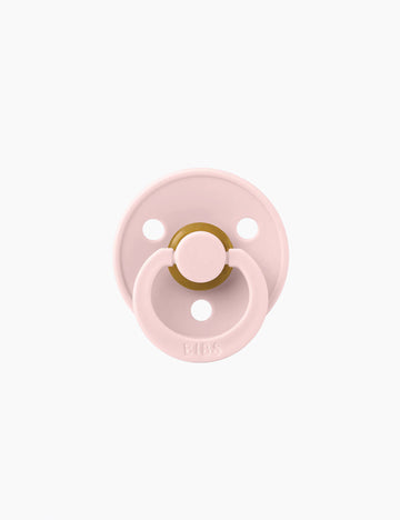 Pink pacifier on a white background