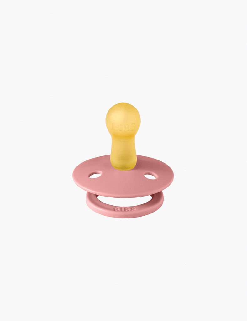 Pink and yellow pacifier on a white background