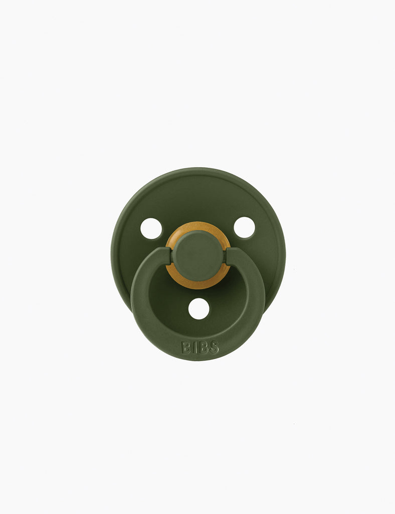 Green baby pacifier on a white background