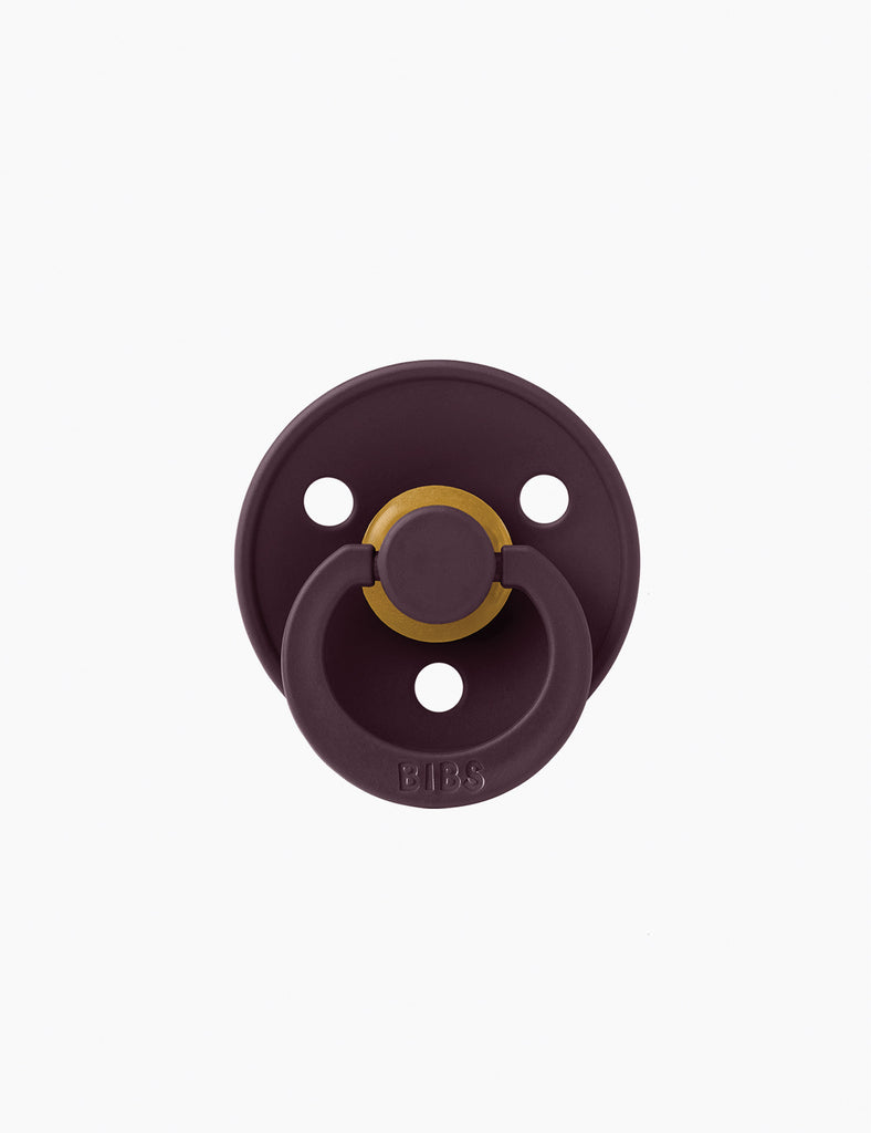 Purple pacifier with gold center on a white background