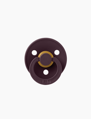 Purple pacifier with gold center on a white background