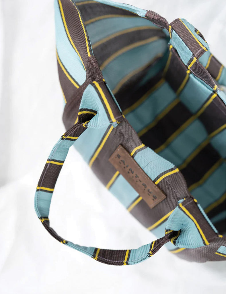 Close-up of a striped bag with a brown strap on a white background