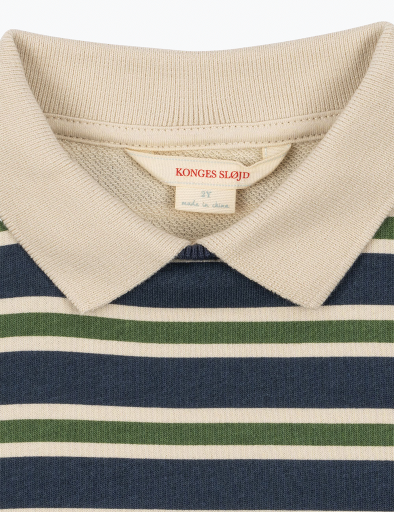 Close-up of a striped shirt with a visible brand label on a white background