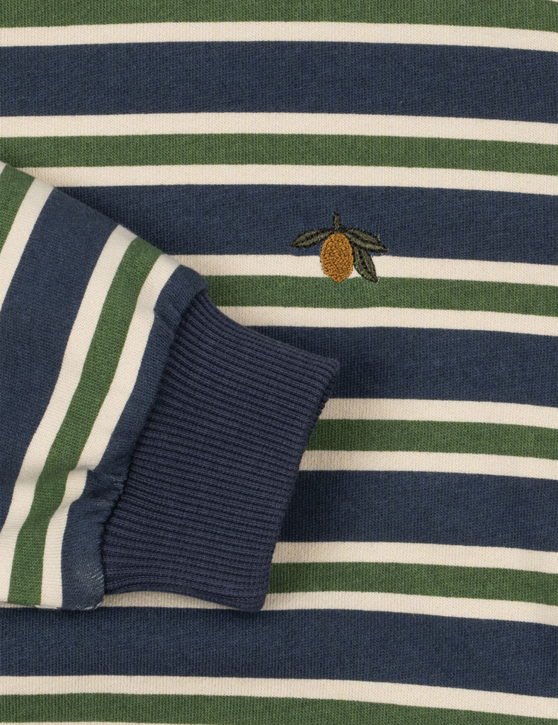Close-up of a striped fabric with a small embroidered design on a blue and green background.
