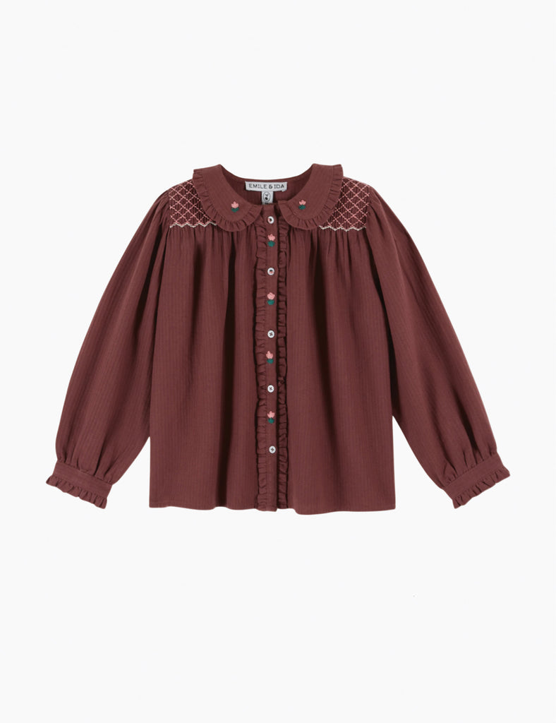 Maroon blouse with lace details on a white background