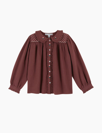 Maroon blouse with lace details on a white background
