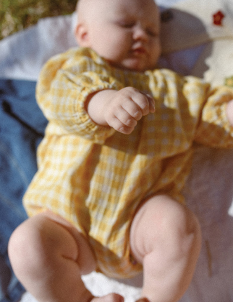 Image of Spring Romoper in Yellow check on a baby girl.