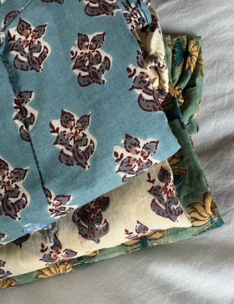Stack of fabric with floral pattern on a plain background