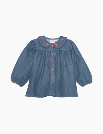 Blue denim top with red strawberry accents on a white background