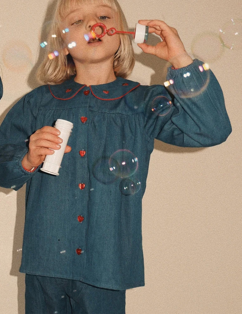 Child blowing bubbles with a beige background