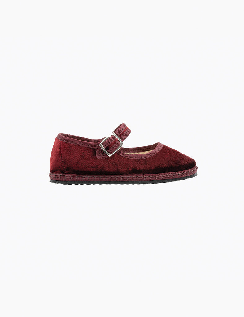 Single maroon shoe with a buckle on a white background