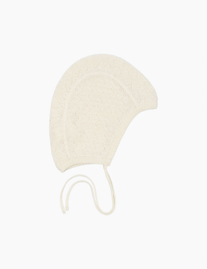 Cream-colored baby bonnet on a white background