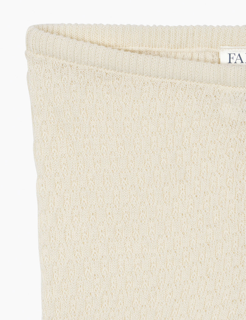 Close-up of a textured beige fabric with a brand label in the corner.