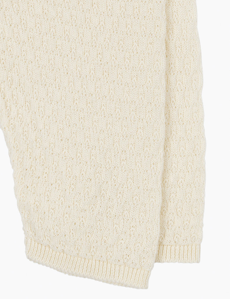 Close-up of a cream-colored knitted sweater on a white background