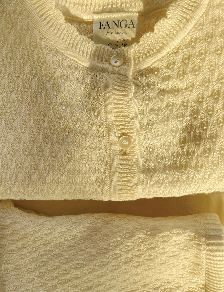 Close-up of a textured beige sweater with 'FANGA' label.