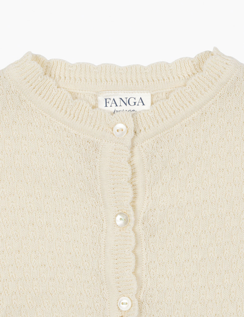 Close-up of a cream-colored cardigan with pearl buttons and 'FANGA' branding.
