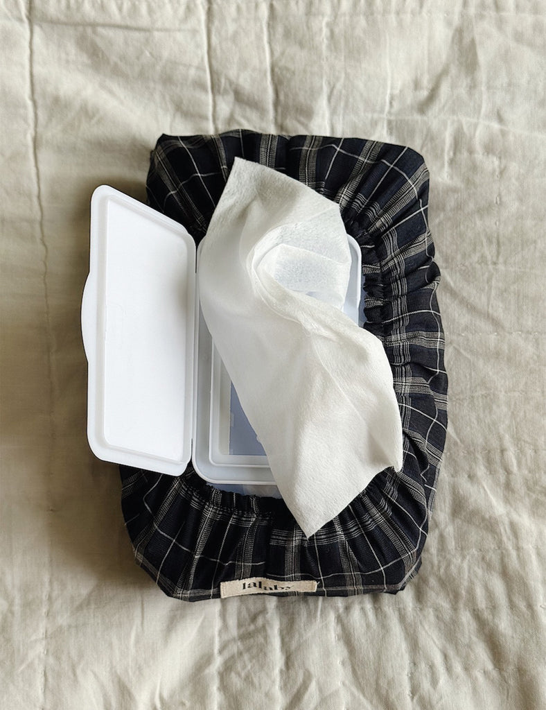 Wet wipes container with plaid cover on a textured surface