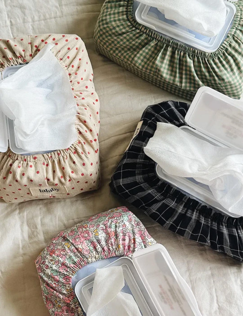 Four fabric-wrapped baby wipes containers on a light surface.