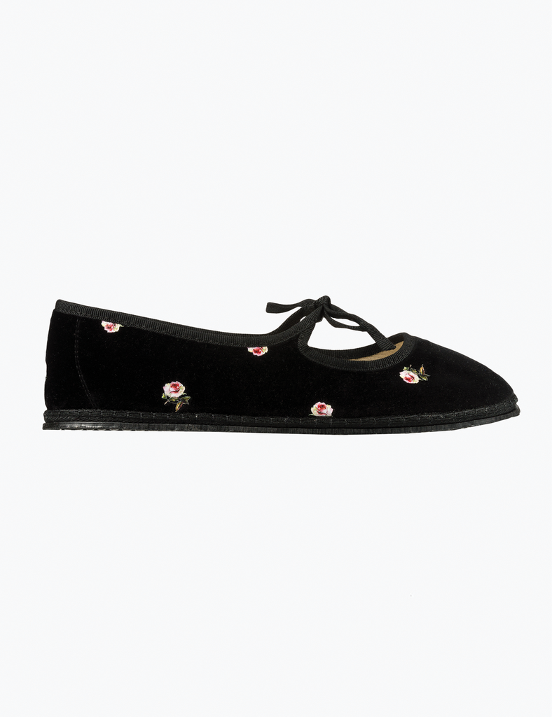 Black flat shoe with floral embroidery on a white background