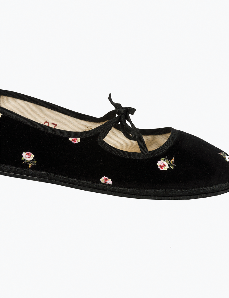 Black shoe with floral embroidery on a white background