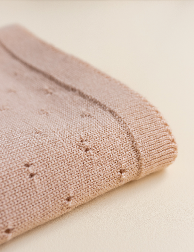 Close-up of a pink knitted fabric on a beige background