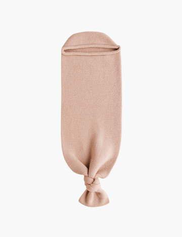 Image of a knitted baby sack in a light pink color in a white background.