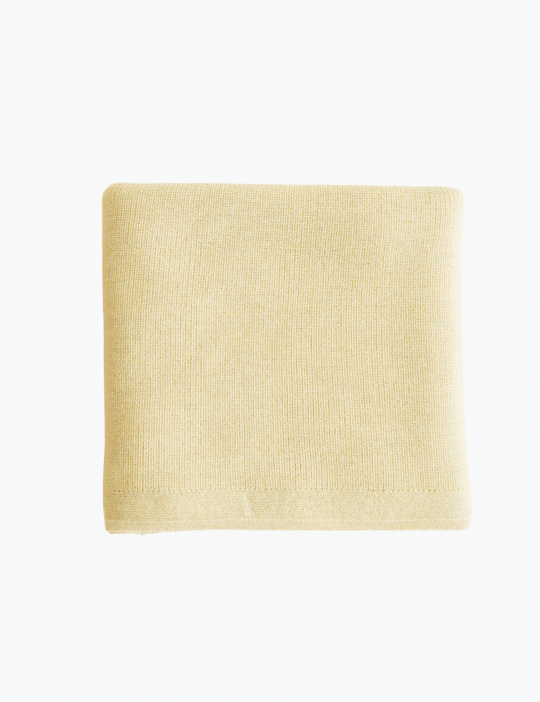 Yellow knitted blanket on a white background.