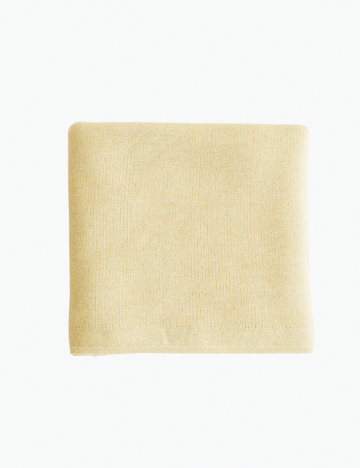 Yellow knitted blanket on a white background.