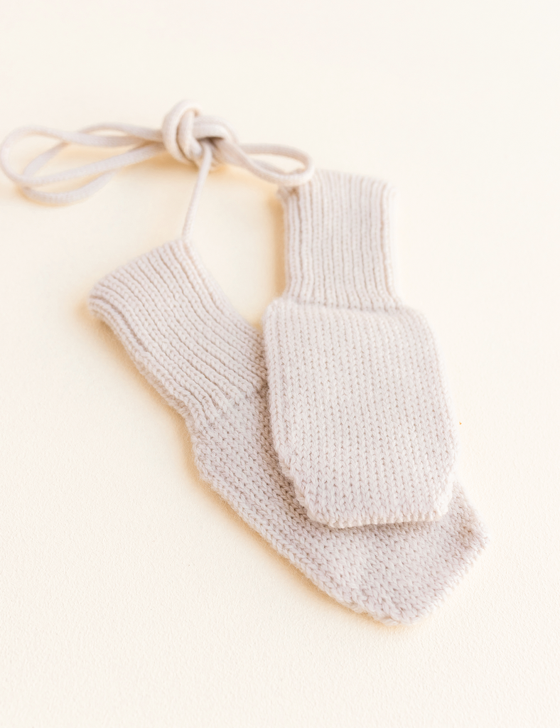 image of cream knitted mittens on a white background.